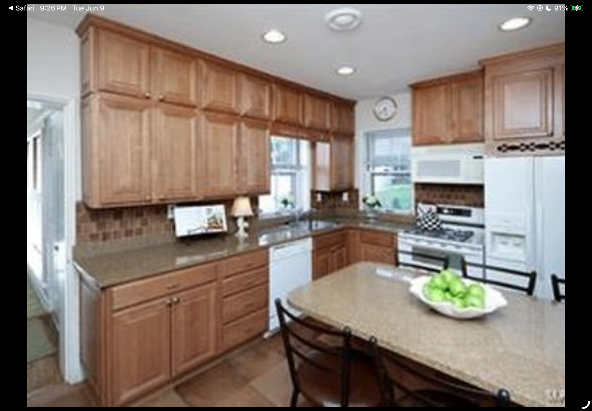 Kitchen with tall wood cabinetry, stone counters and an island dining area