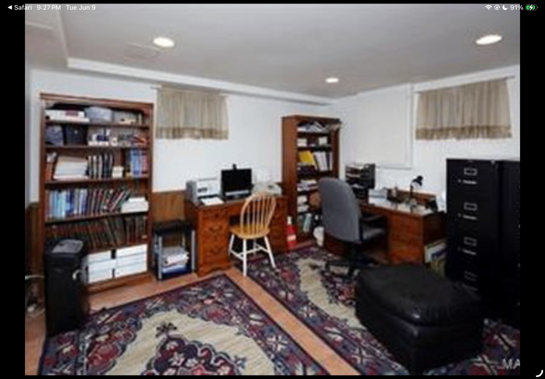 Home office with built-in desks, bookcases and patterned area rugs