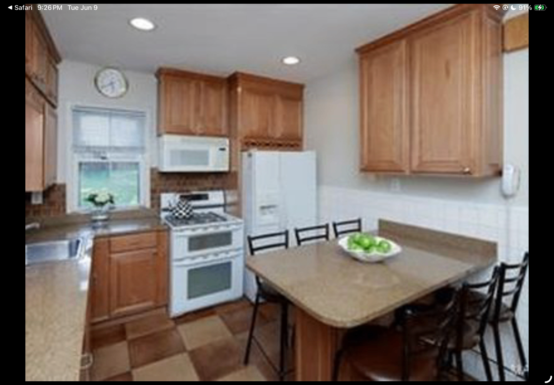 Kitchen with breakfast table, wood cabinetry and white appliances