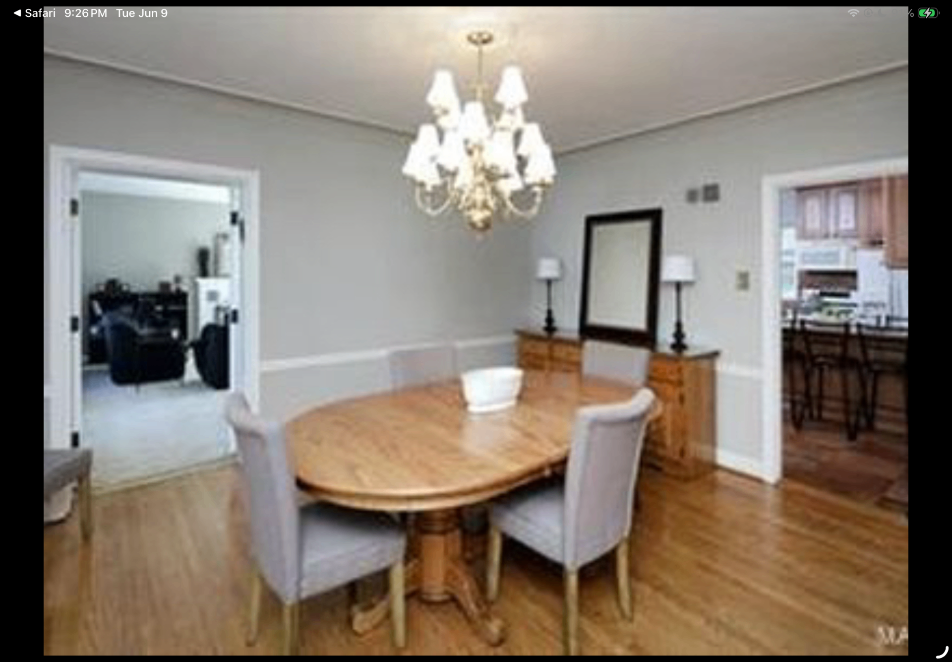 Formal dining room with chandelier, wood table and adjacent kitchen doorway